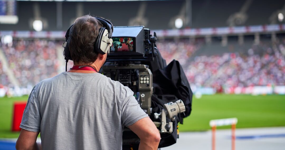 Cameraman at sports event capturing track and field athletes
