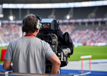 Cameraman at sports event capturing track and field athletes