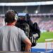 Cameraman at sports event capturing track and field athletes
