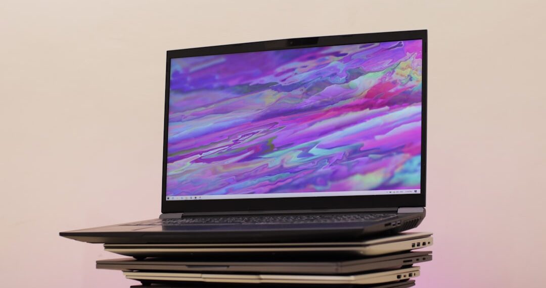 Gaming laptop on top of stacked laptops