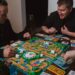 A group of friends play a classic board game.